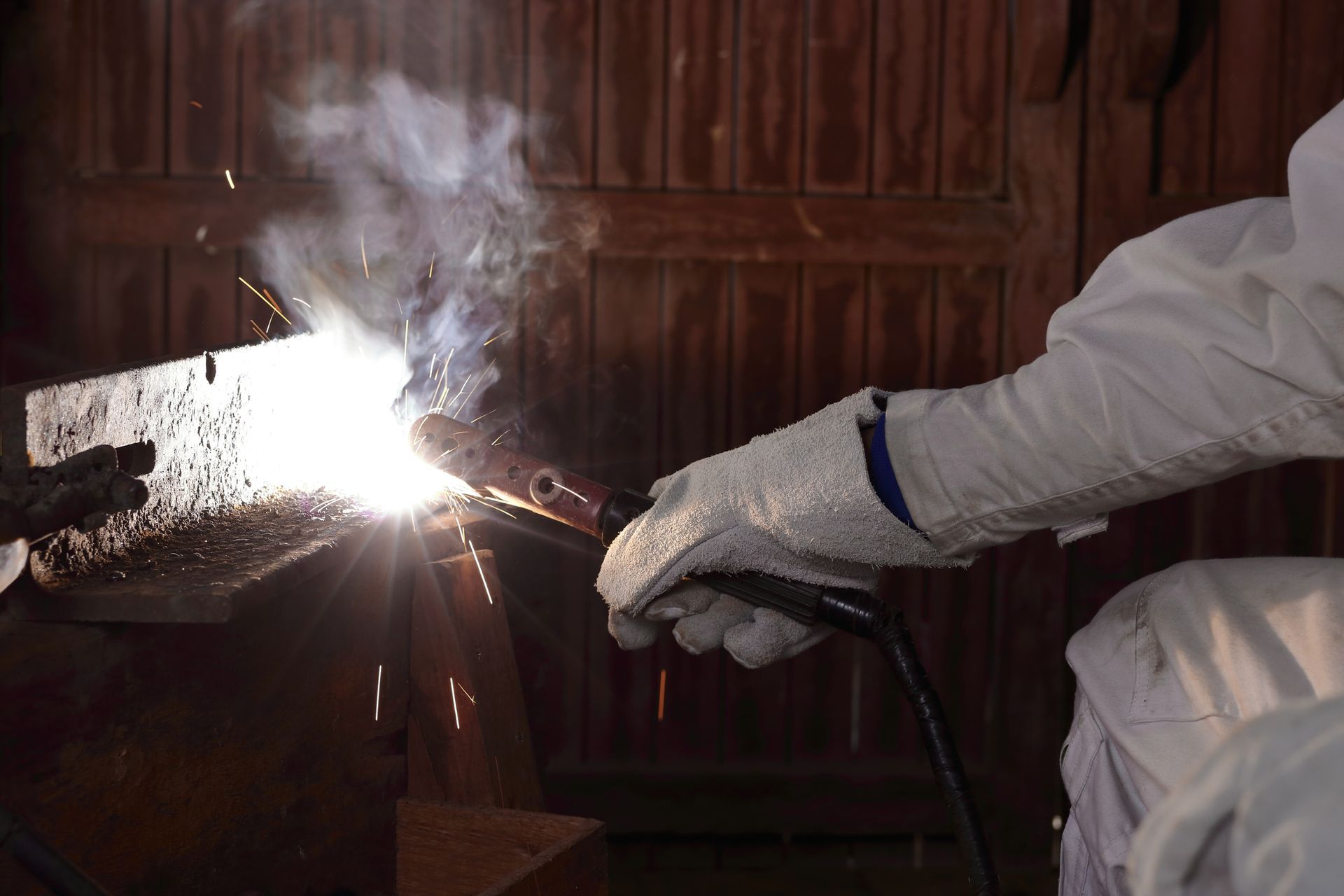 Person welding a metal piece.