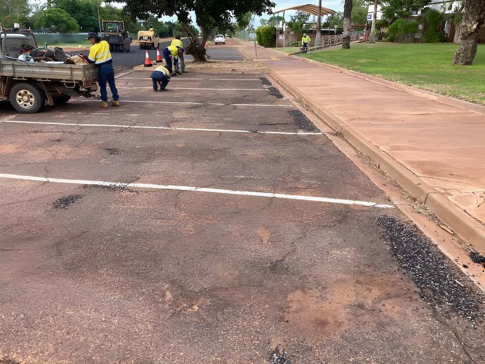 A Group of People Are Working on a Parking Lot — F & J Bitumen Services in Humpty Doo, NT