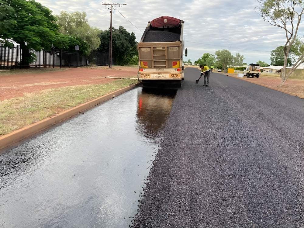 A Truck is Driving Down with Wet Sealing in the Road — F & J Bitumen Services in Humpty Doo, NT