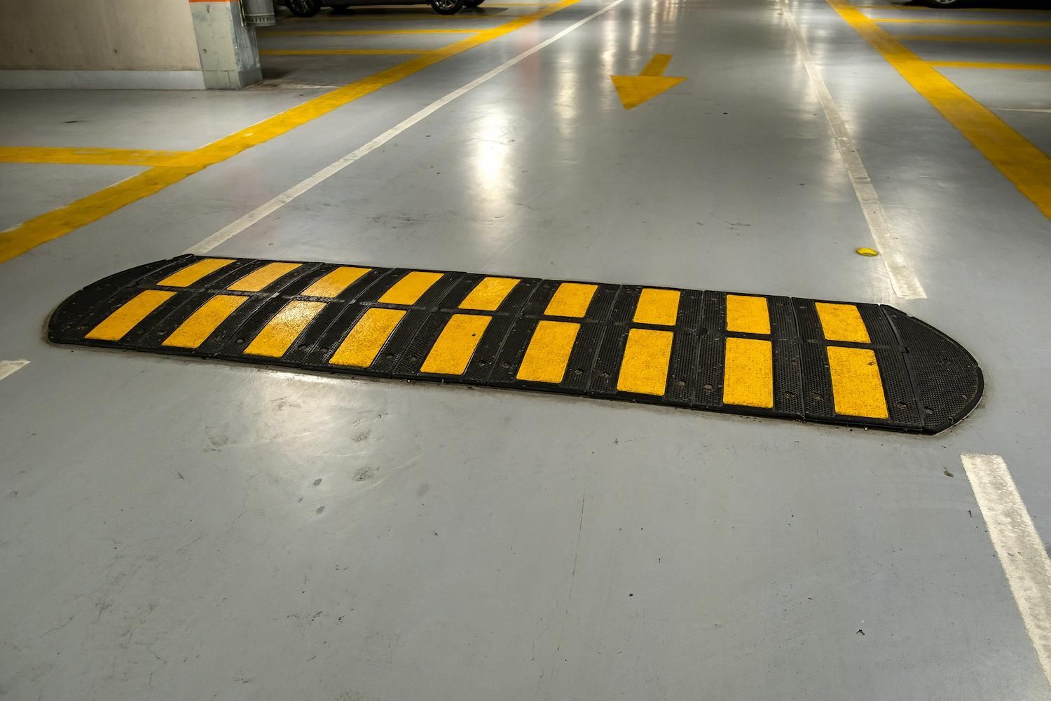 A Black and Yellow Speed Bump in a Parking Garage — F & J Bitumen Services in Humpty Doo, NT
