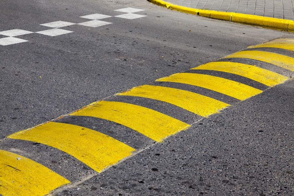 A Yellow and Black Speed Bump on the Side of a Road — F & J Bitumen Services in Katherine, NT