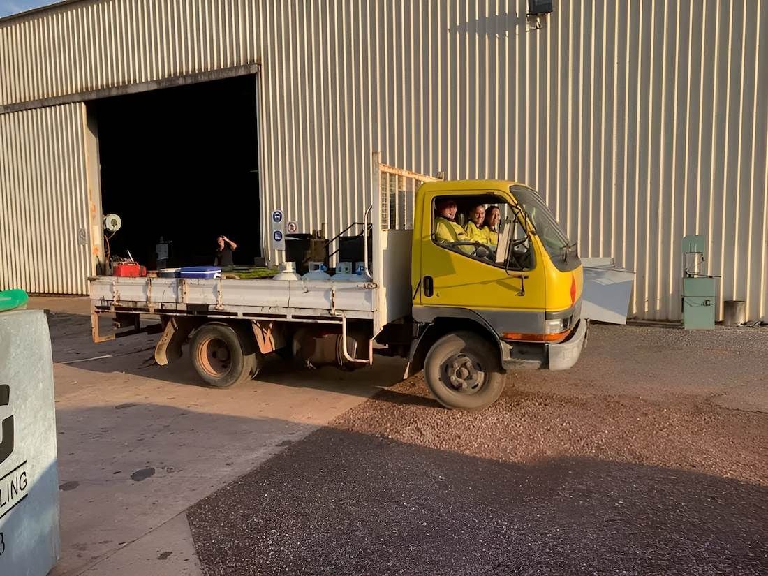 A Yellow Truck is Parked in Front of a Building — F & J Bitumen Services in Humpty Doo, NT