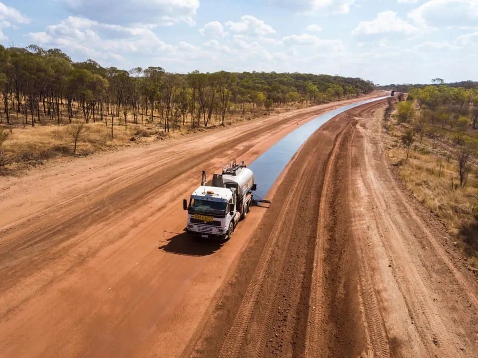 An Aerial View of a Truck Driving Down a Dirt Road — F & J Bitumen Services in Humpty Doo, NT