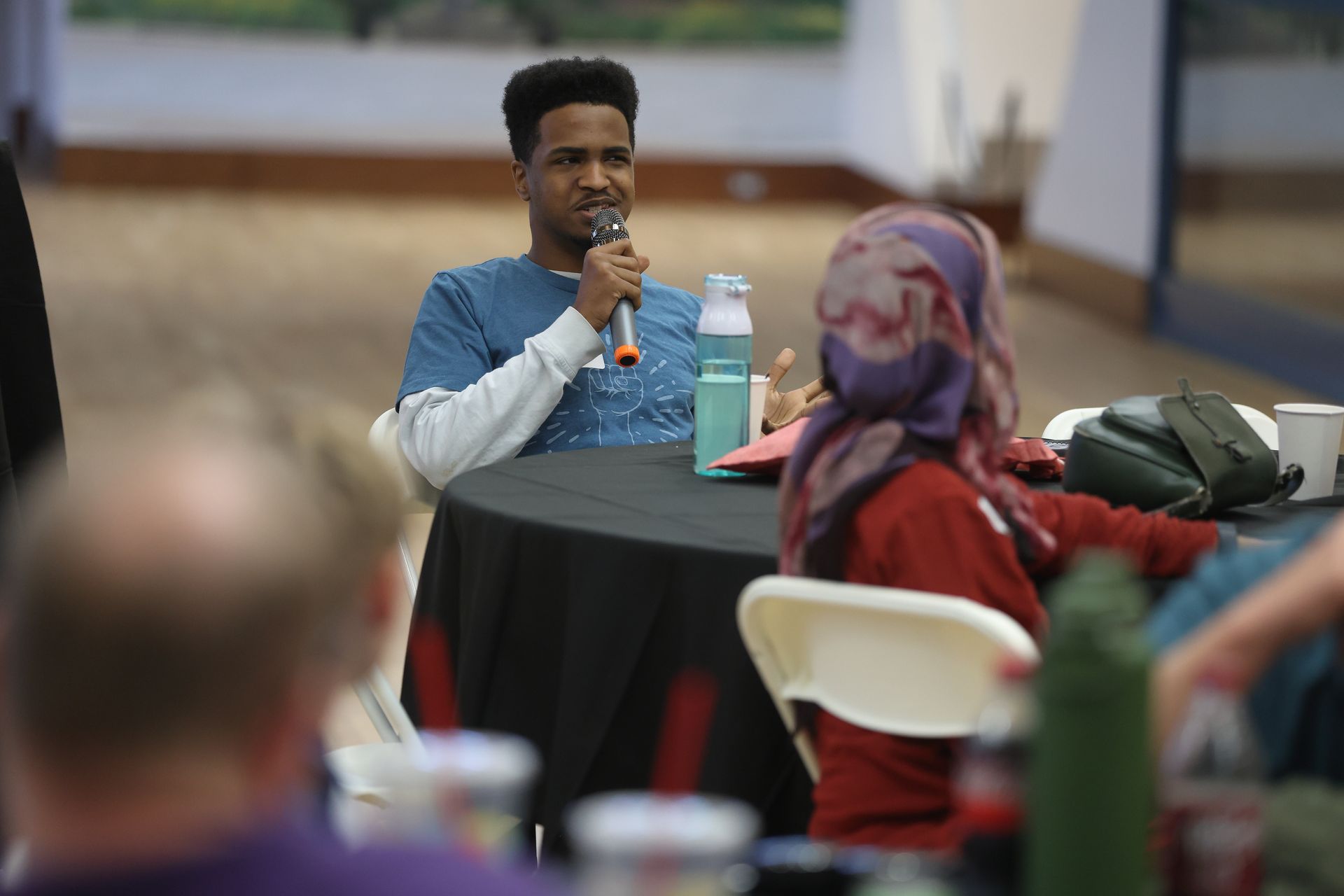 A YLA graduate speaking into a microphone