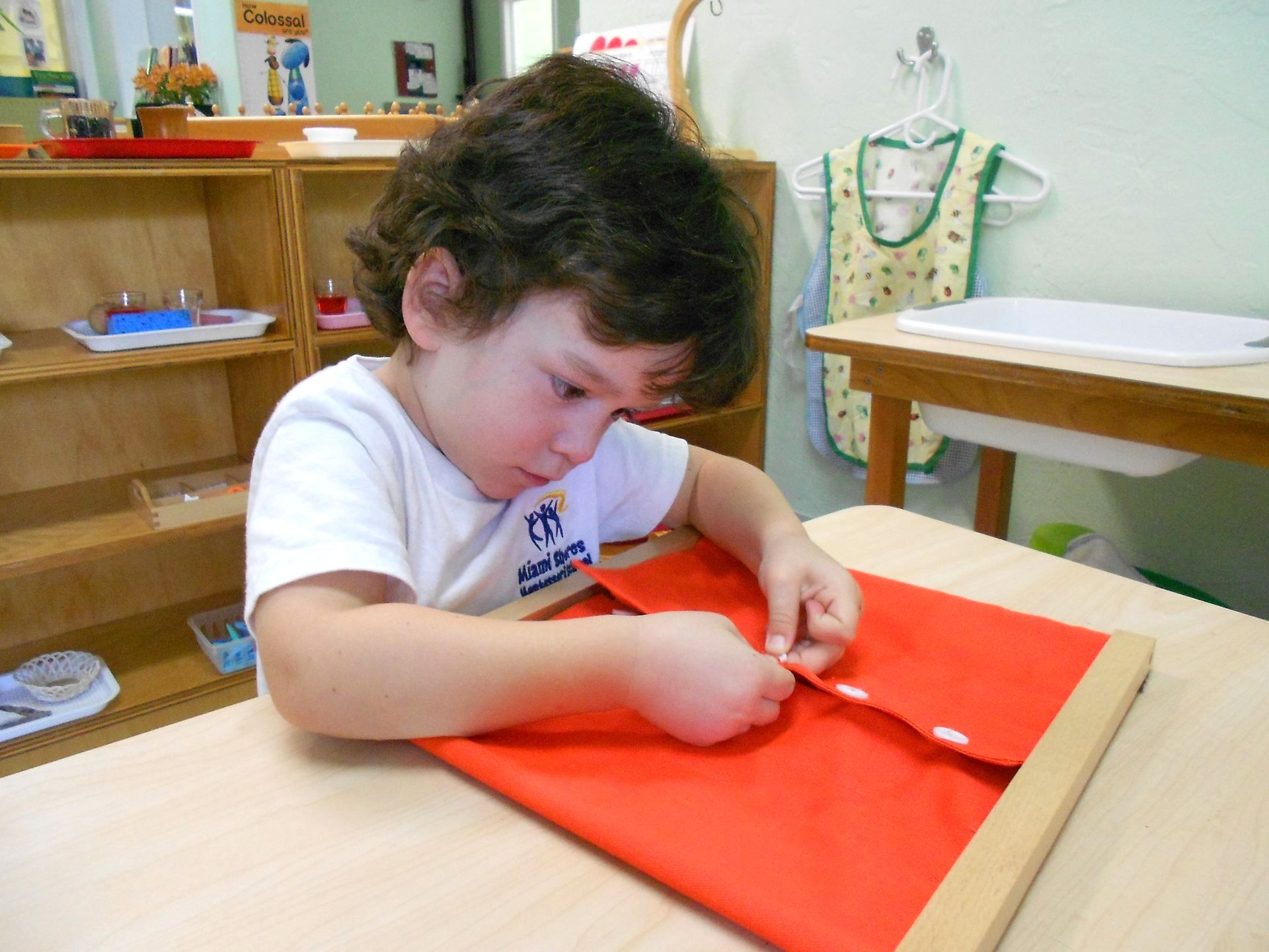 montessori preschool child working geometric volumes