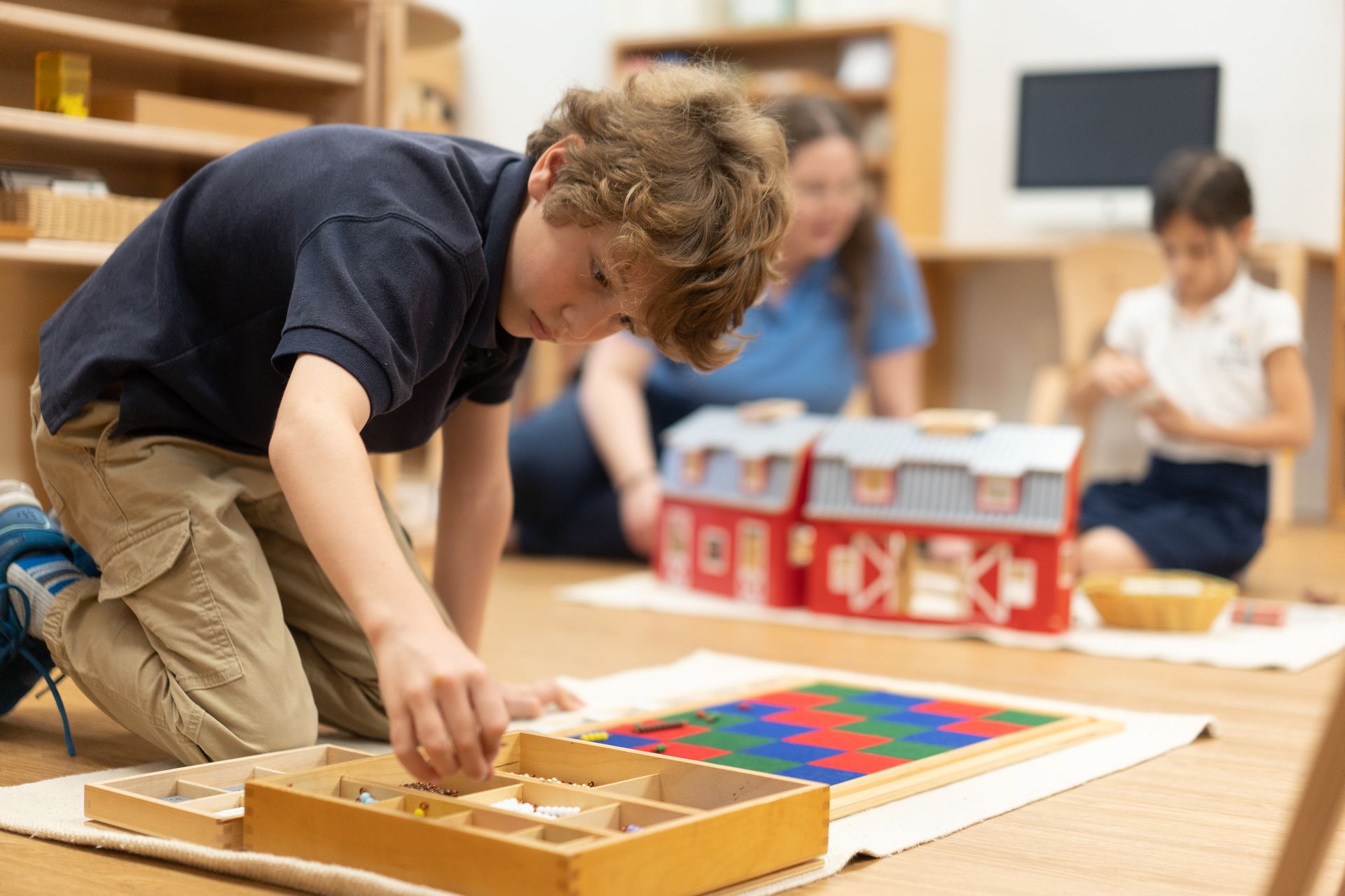A Montessori child is working with a math material