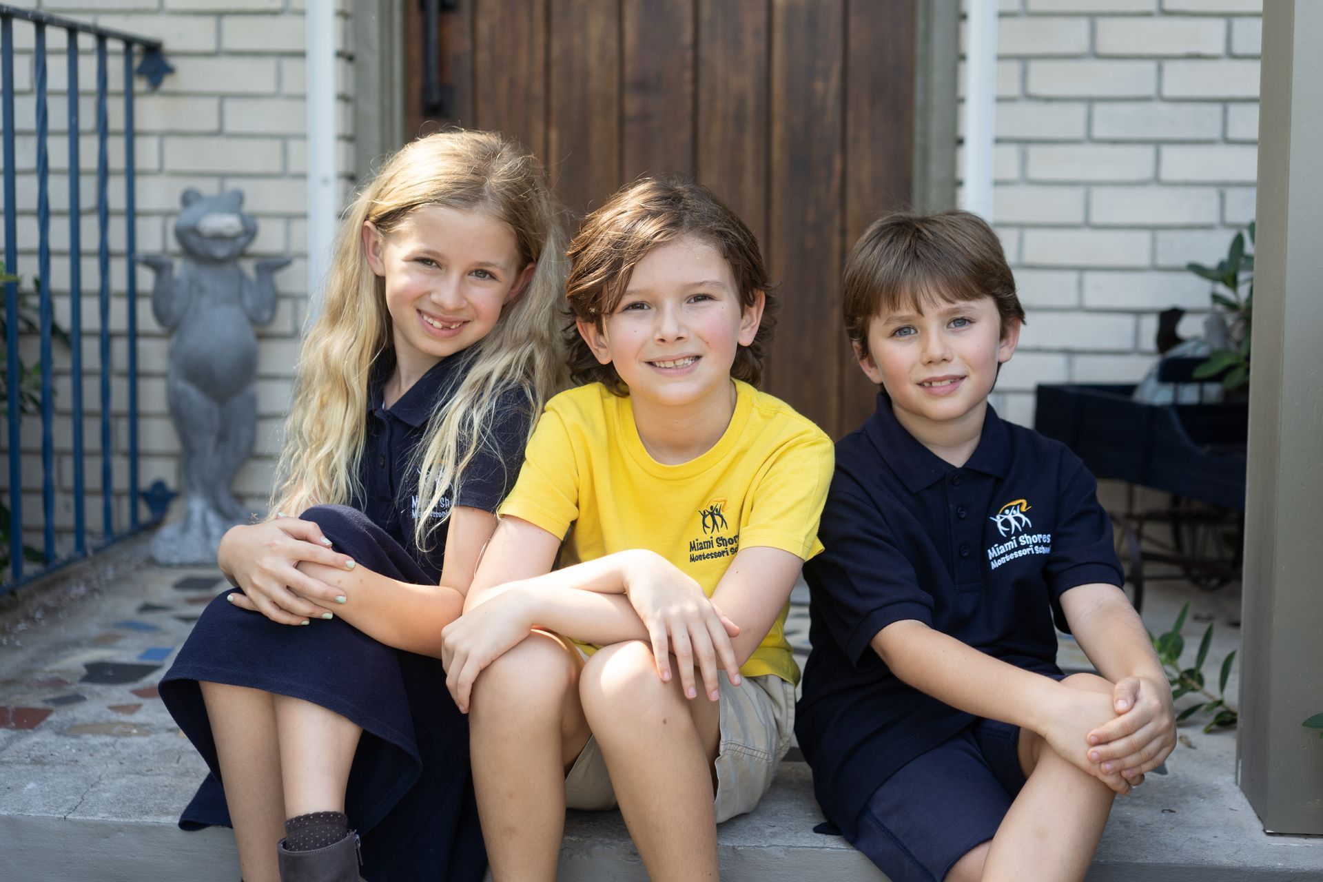 Montessori children are sitting on a set of steps.
