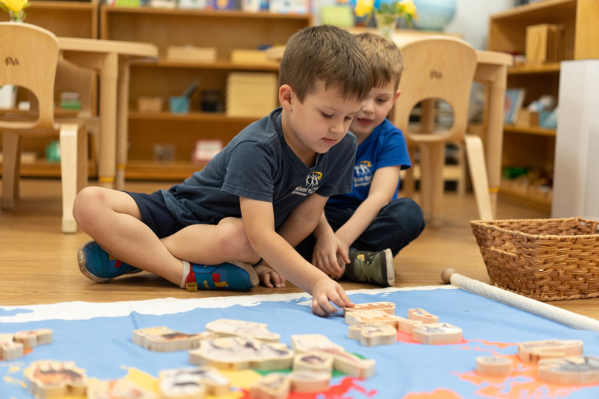 Montessori child is sitting on the floor working with wooden blocks.