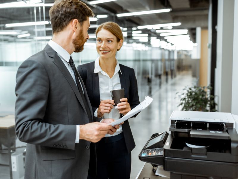 Man and woman using a multifunction printer