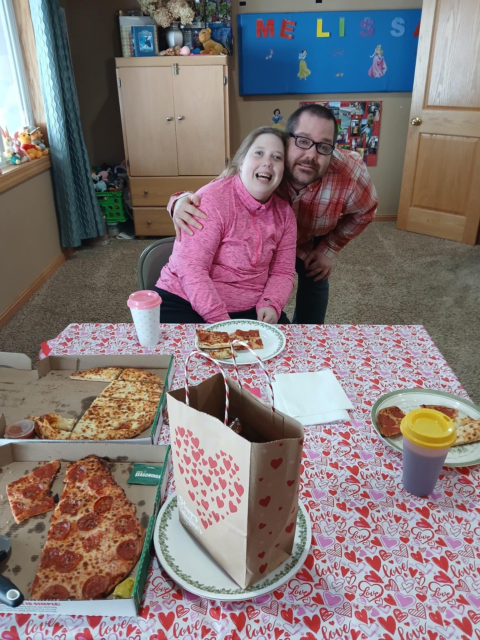 A man and a woman are sitting at a table with pizza.