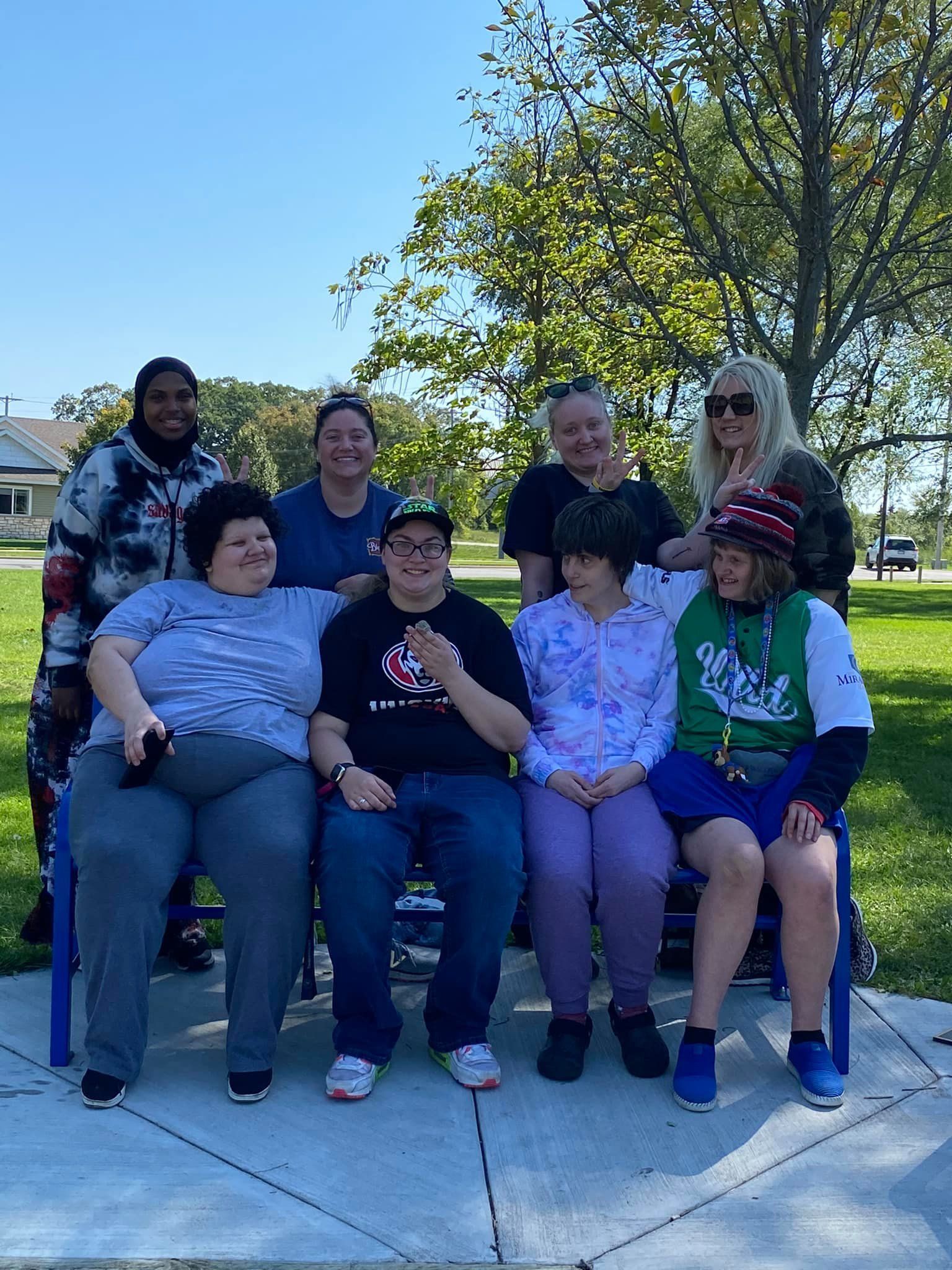 A group of people are posing for a picture in a park.