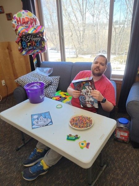 A man is sitting on a couch reading a book.