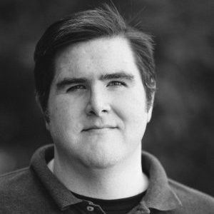 A black and white photo of a man in a polo shirt.