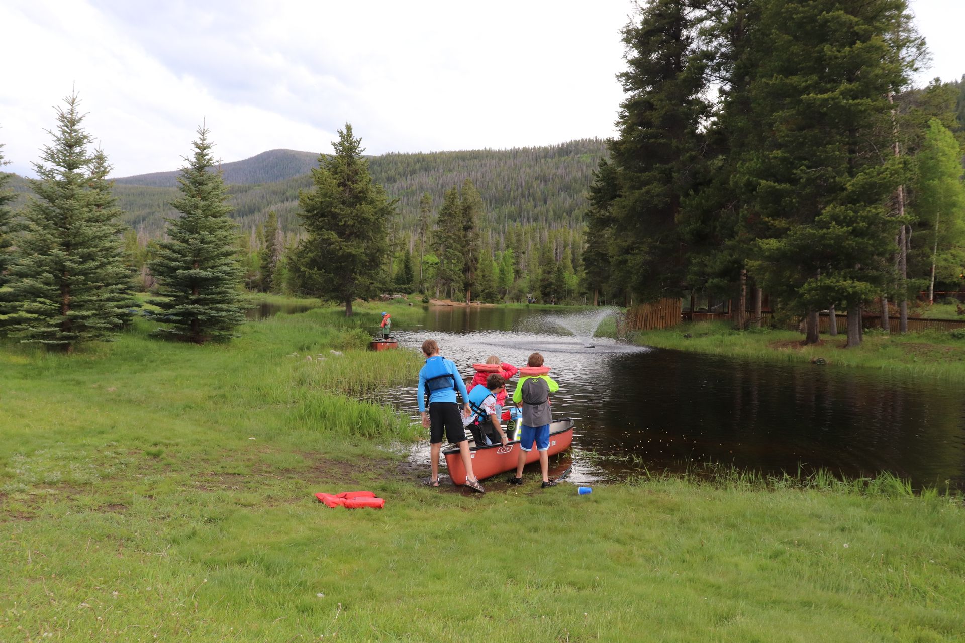 A group of people are standing next to a raft in the water.