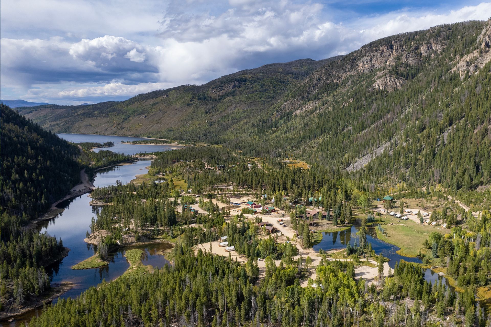 An aerial view of a river surrounded by mountains and trees.