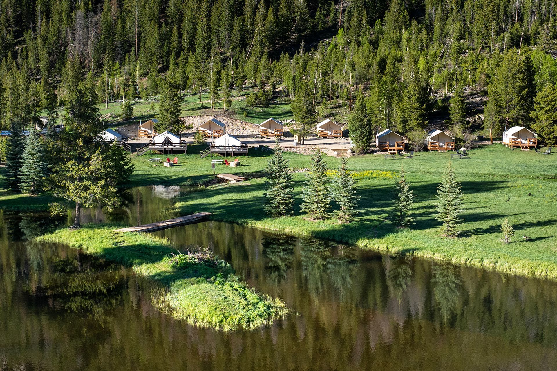 A small island in the middle of a lake in the middle of a forest.