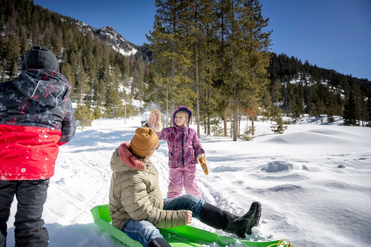 A child is riding a snow tube down a snowy hill.