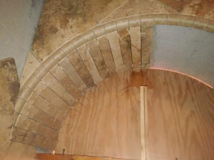 A spiral staircase is being built on a wooden floor.