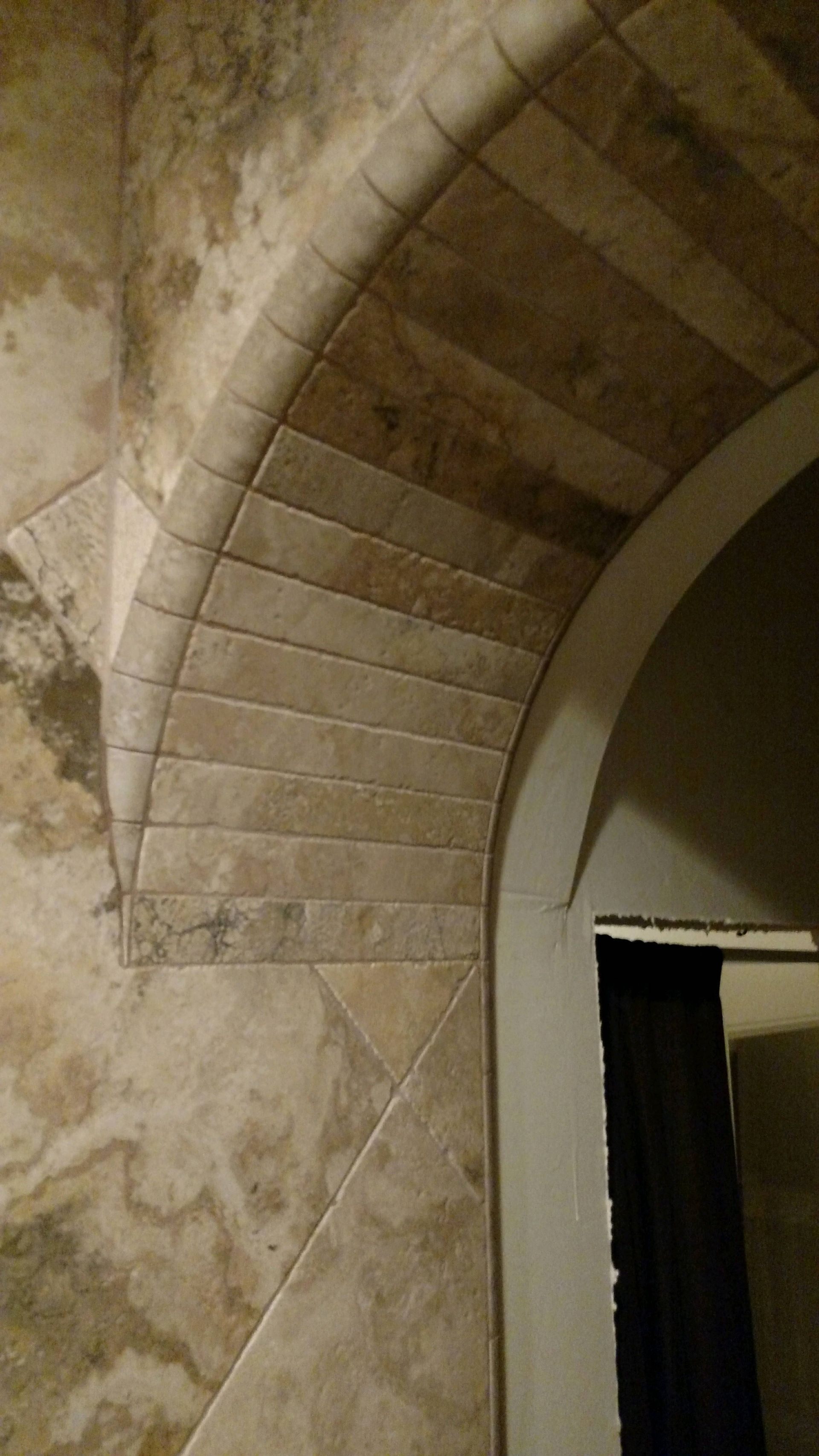 A close up of a tiled archway in a room.