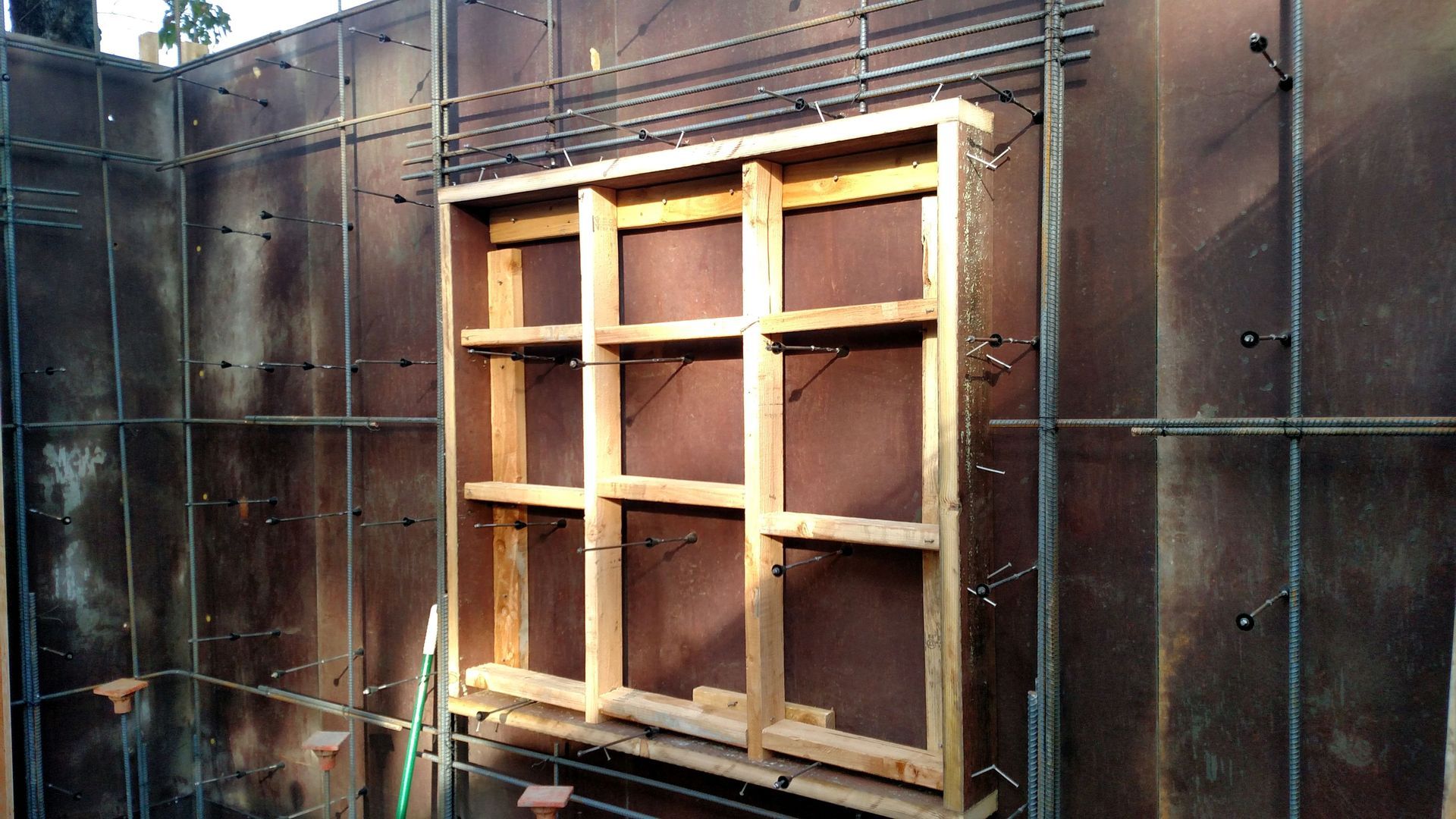 A wooden frame is attached to a metal wall