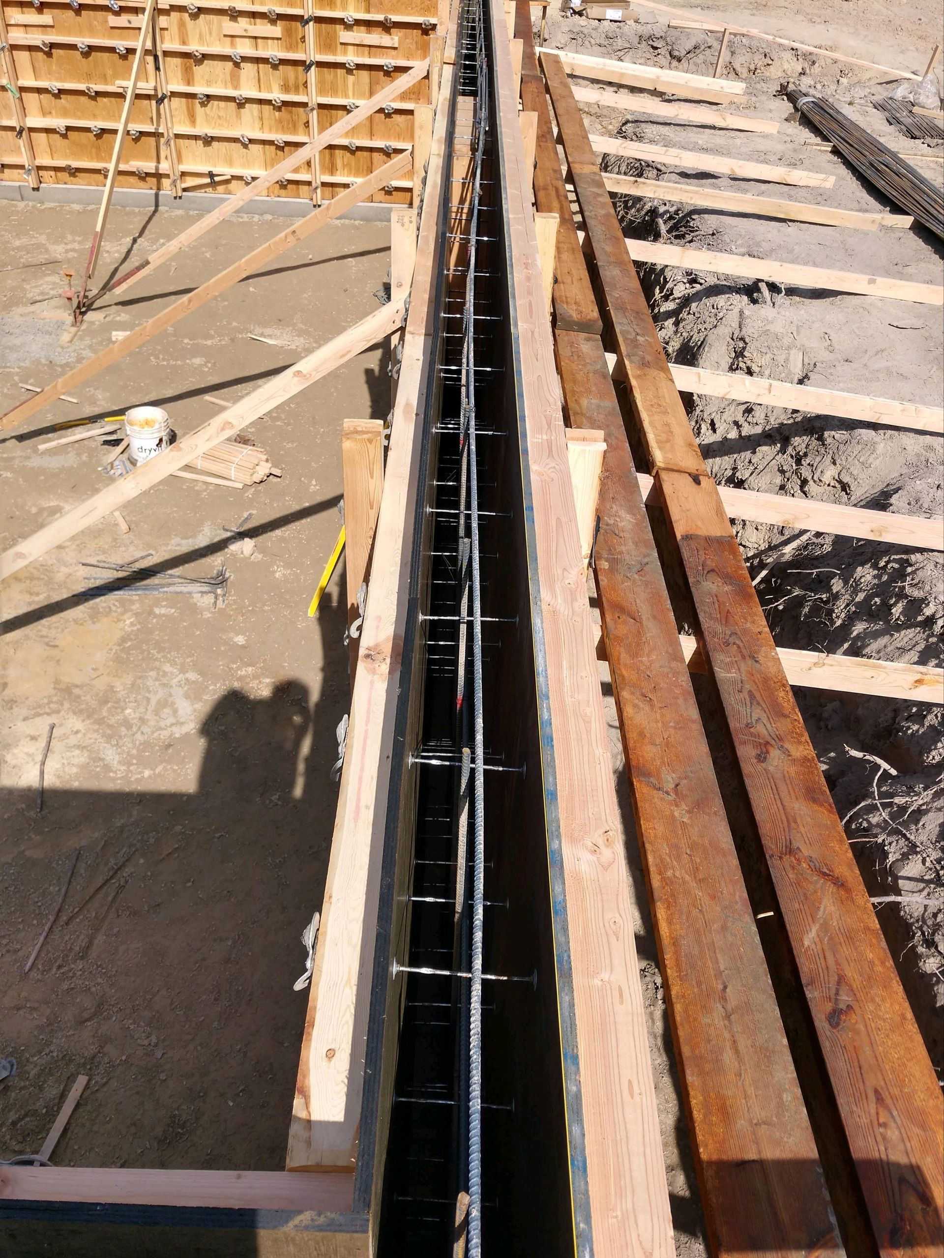 A concrete wall is being built with wooden beams