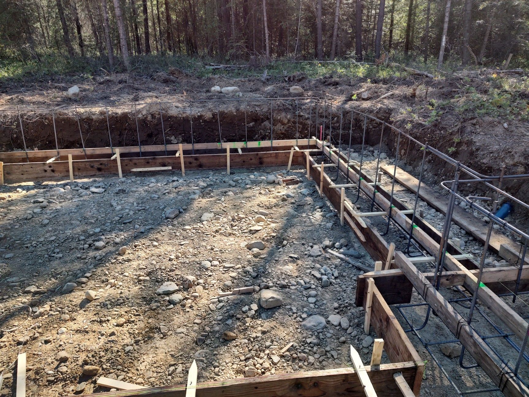 A foundation for a house is being built in the woods.
