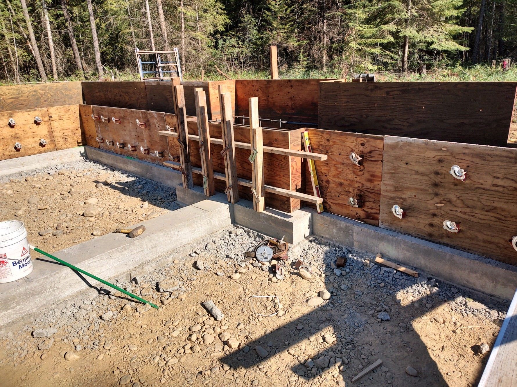 A wooden fence is being built on top of a dirt field.