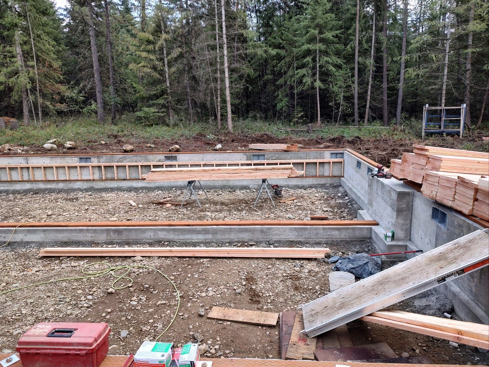 A construction site with a red toolbox in the foreground.