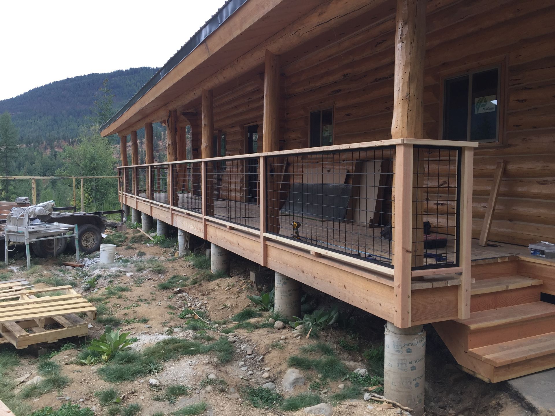A log cabin with a large porch and stairs