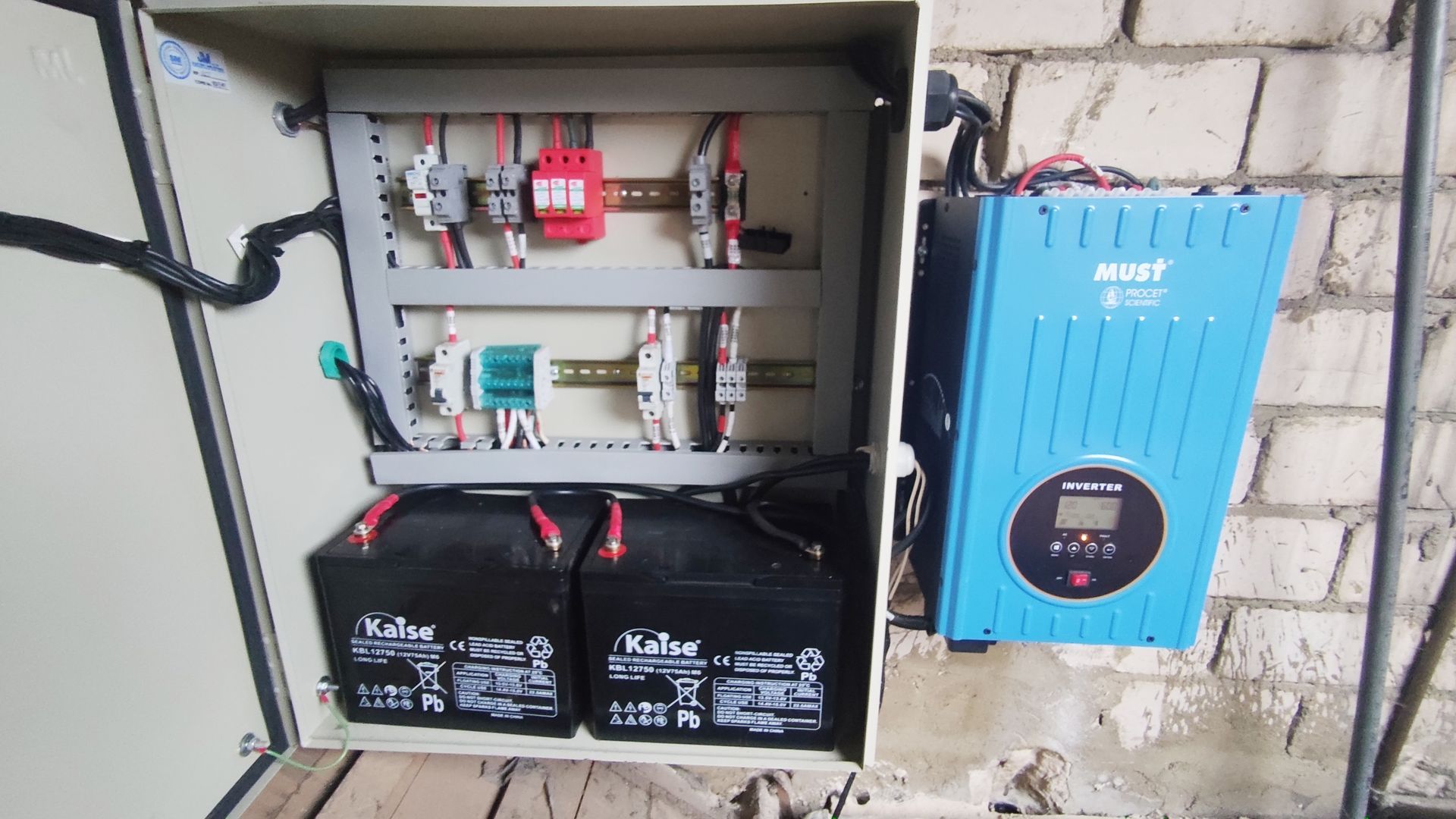 Una caja con tres baterías y un inversor en su interior.