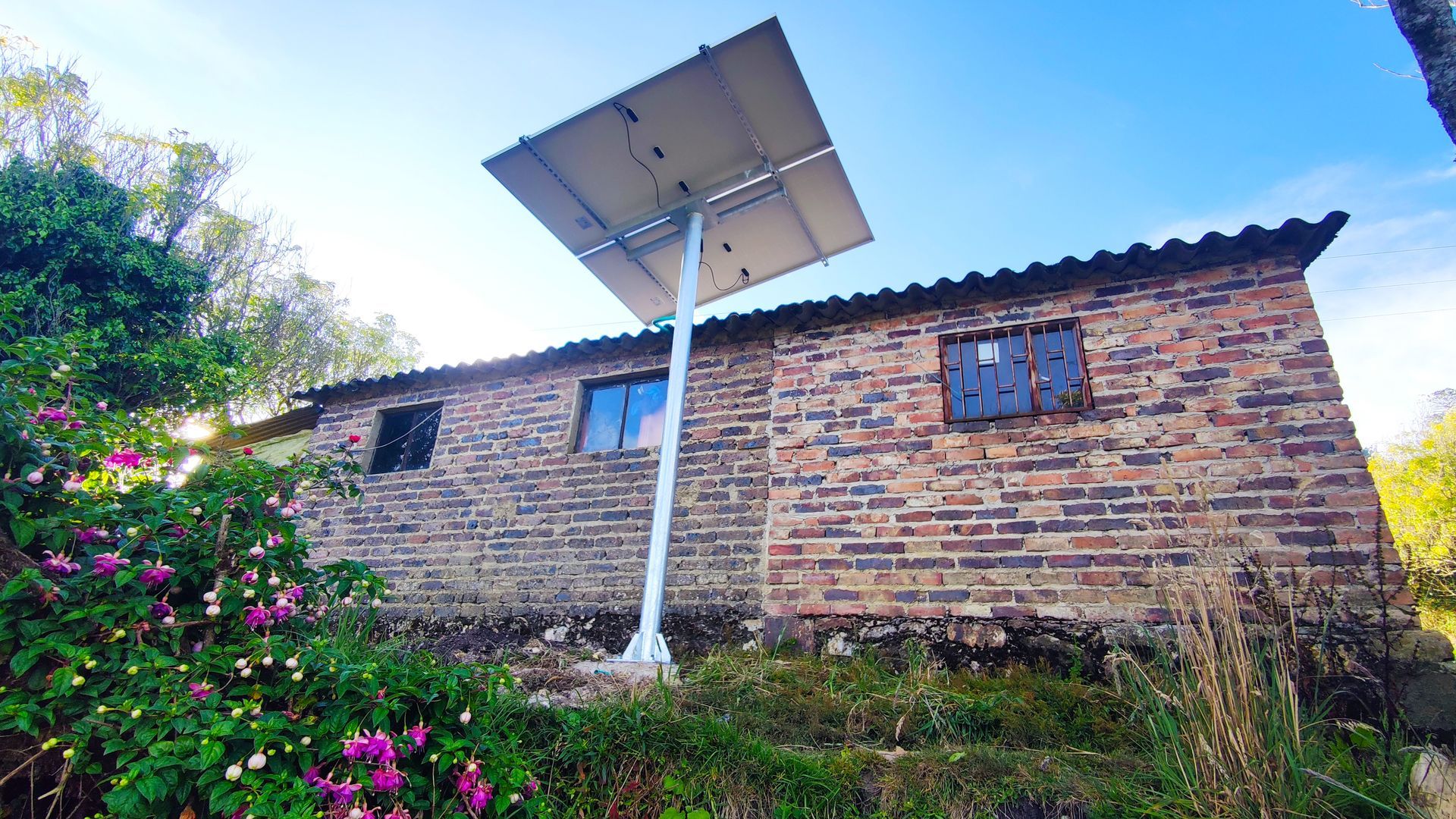 Una casa de ladrillo con un panel solar en el costado.