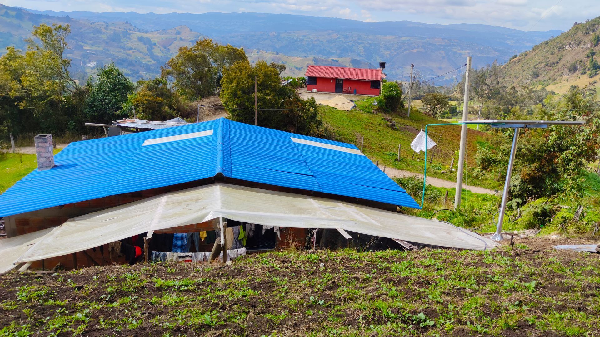 Una casa con techo azul está situada en medio de un campo.