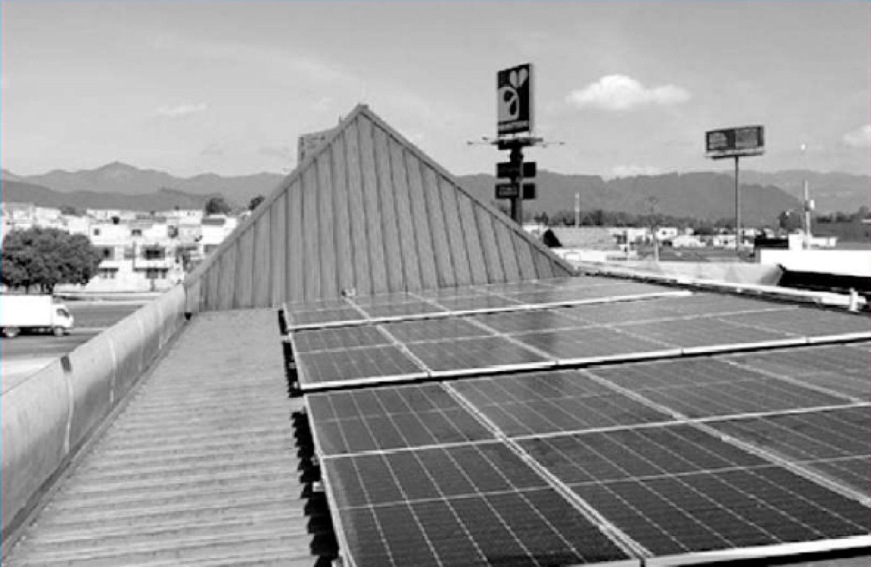 Una fotografía en blanco y negro de paneles solares en el techo de un edificio.