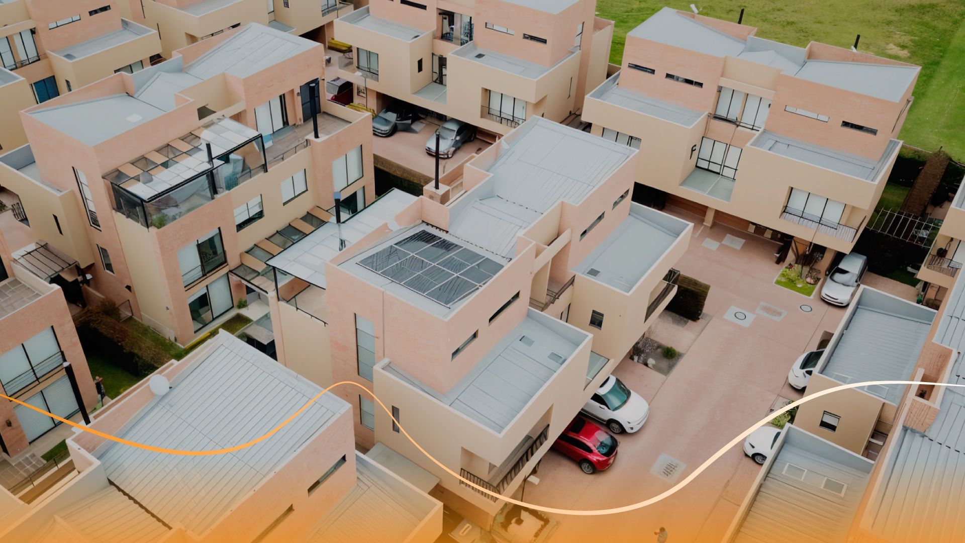 Una vista aérea de una zona residencial con muchos edificios y coches aparcados delante de ellos.