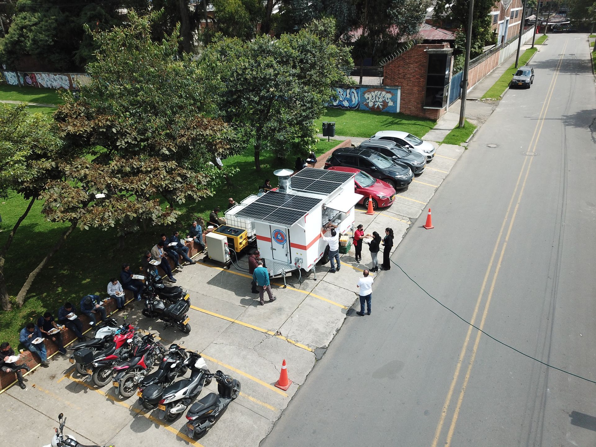 Una vista aérea de un estacionamiento lleno de motocicletas y automóviles.