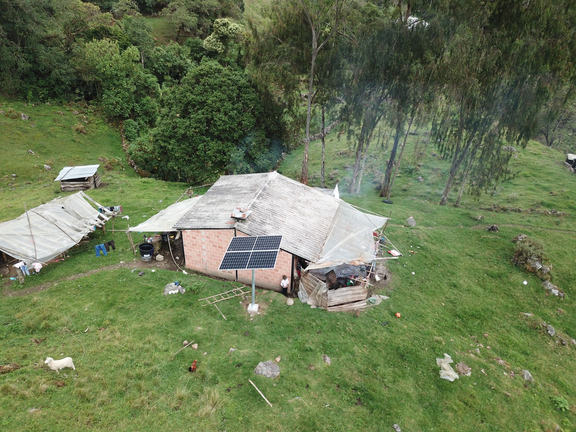 Una vista aérea de una pequeña casa en medio de un campo de hierba.