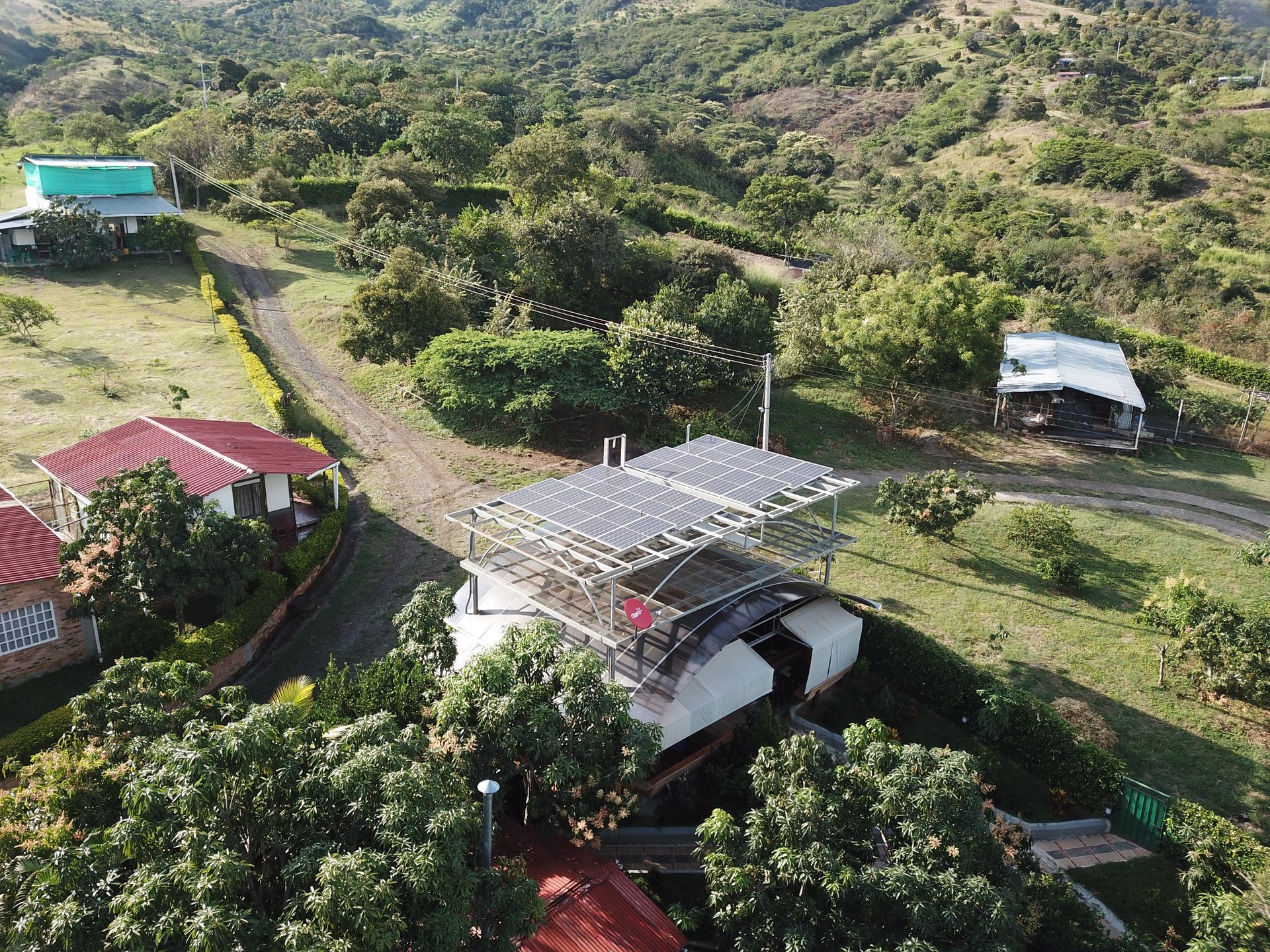 Una vista aérea de una casa en la cima de una colina rodeada de árboles.