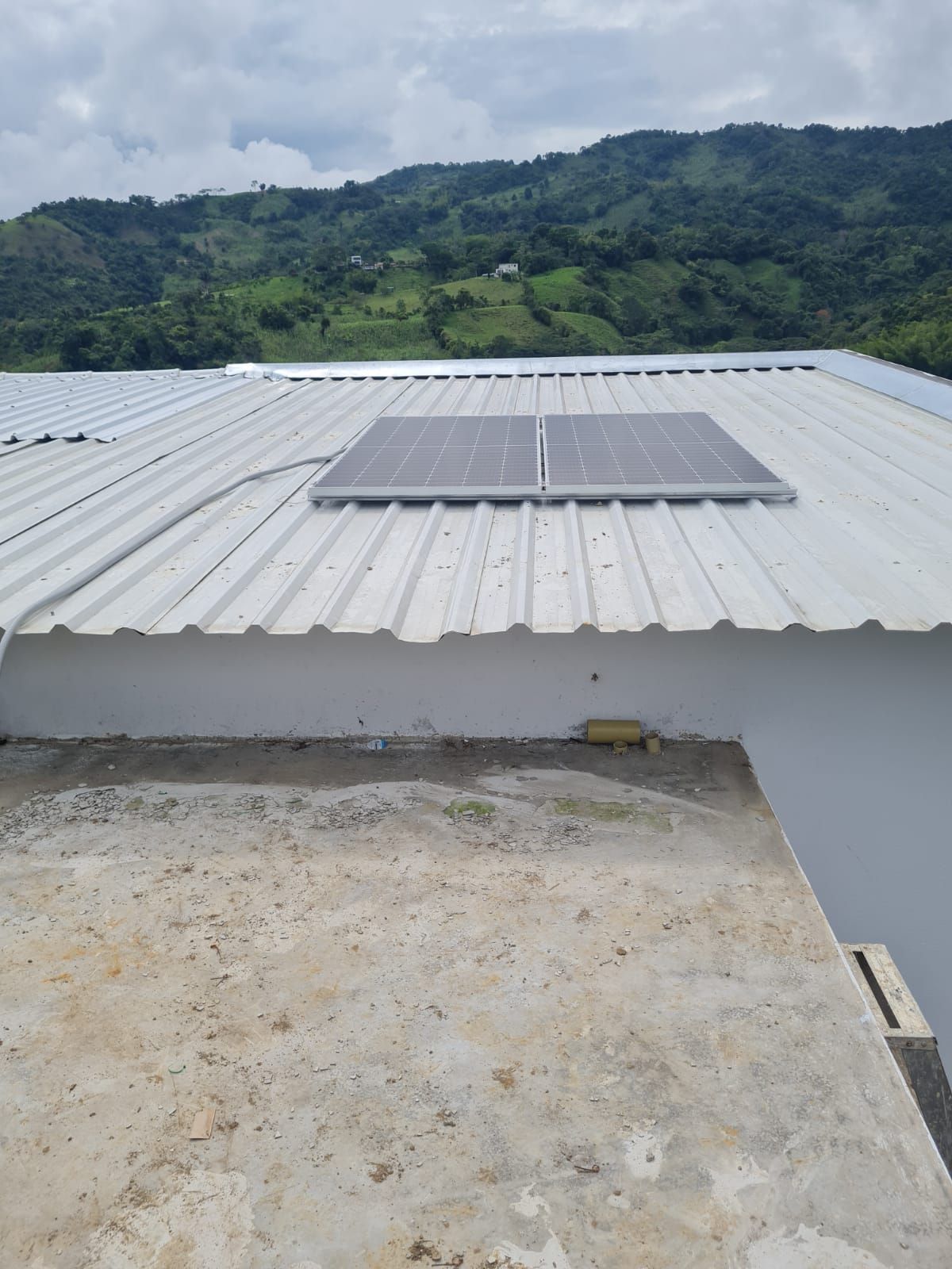 Un panel solar está situado encima de un techo blanco.