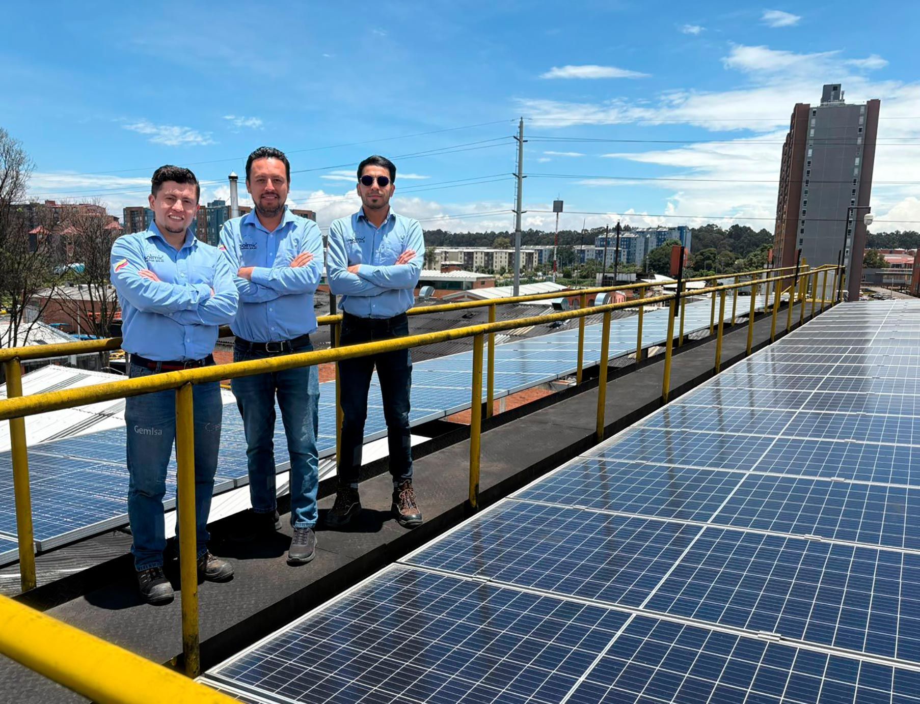 Cuatro personas con cascos y máscaras se encuentran sobre un techo con paneles solares.
