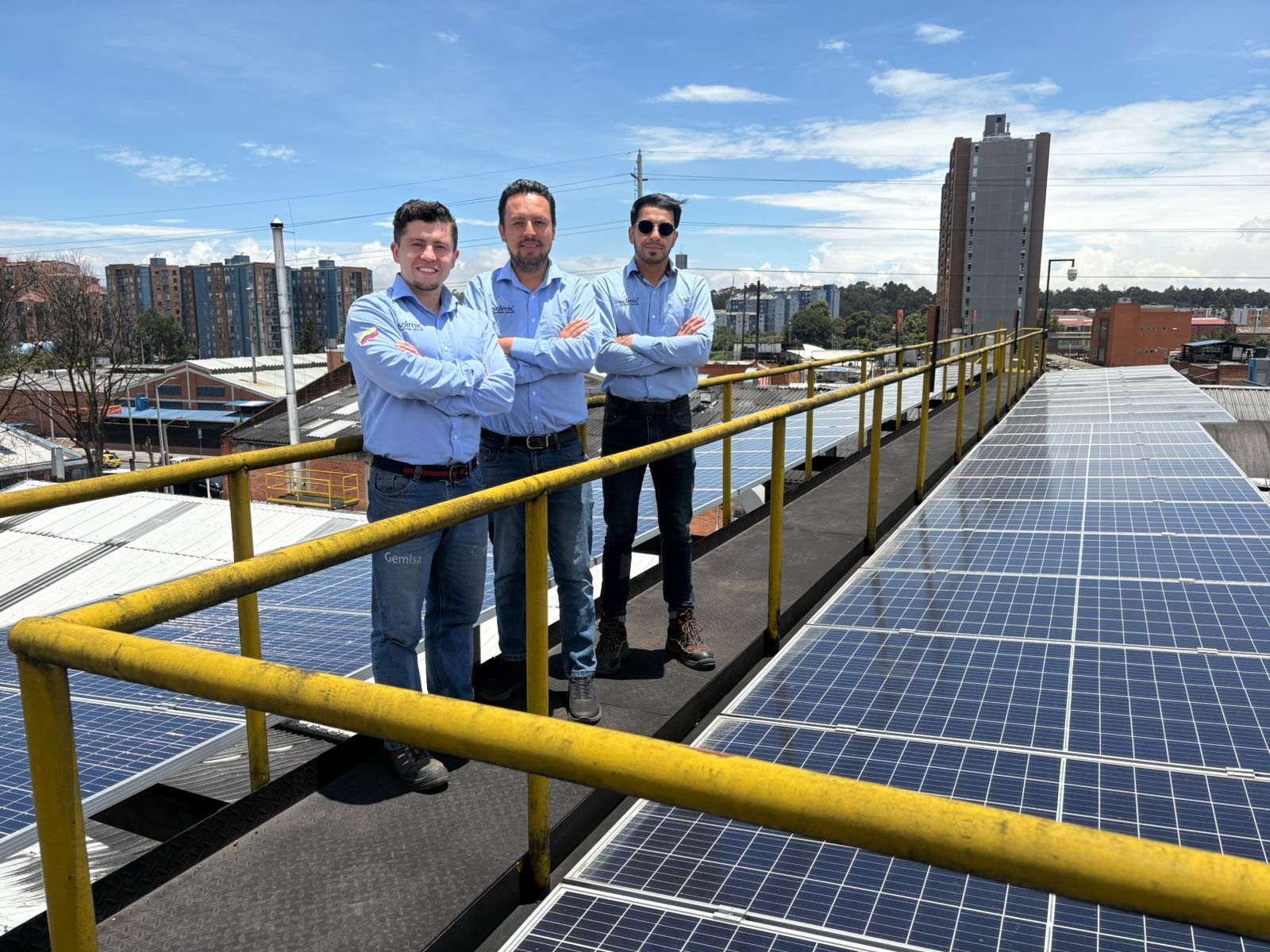 Cuatro personas con cascos y máscaras se encuentran sobre un techo con paneles solares.