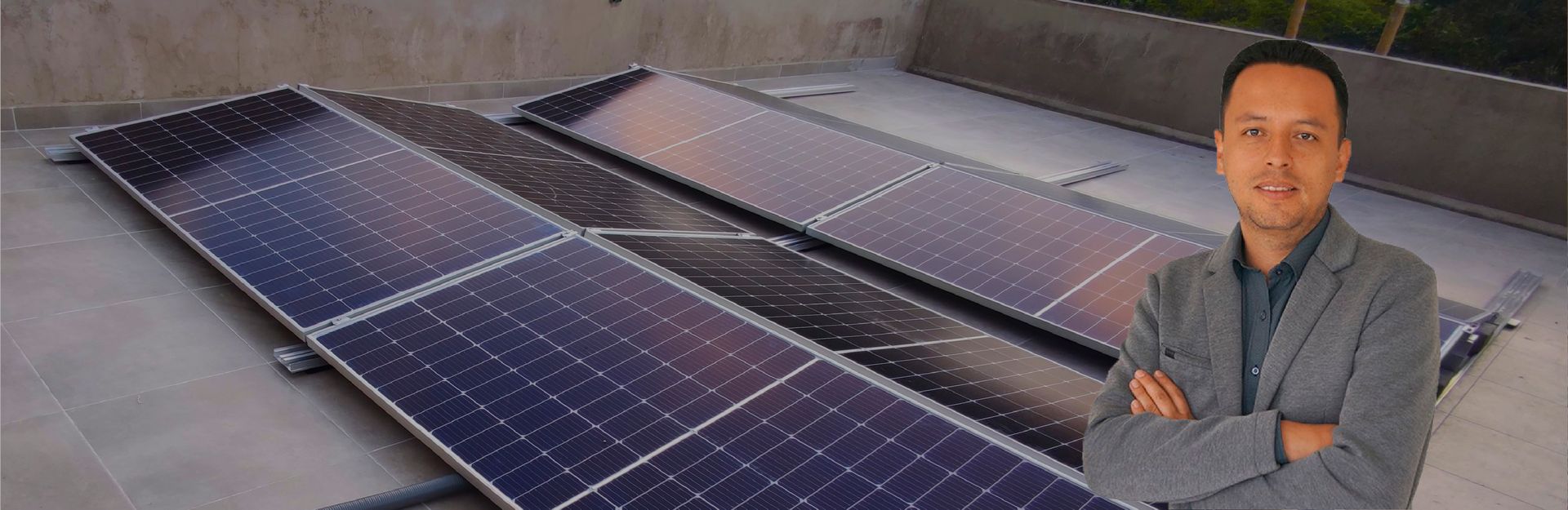 Un hombre está parado frente a una fila de paneles solares en un tejado.