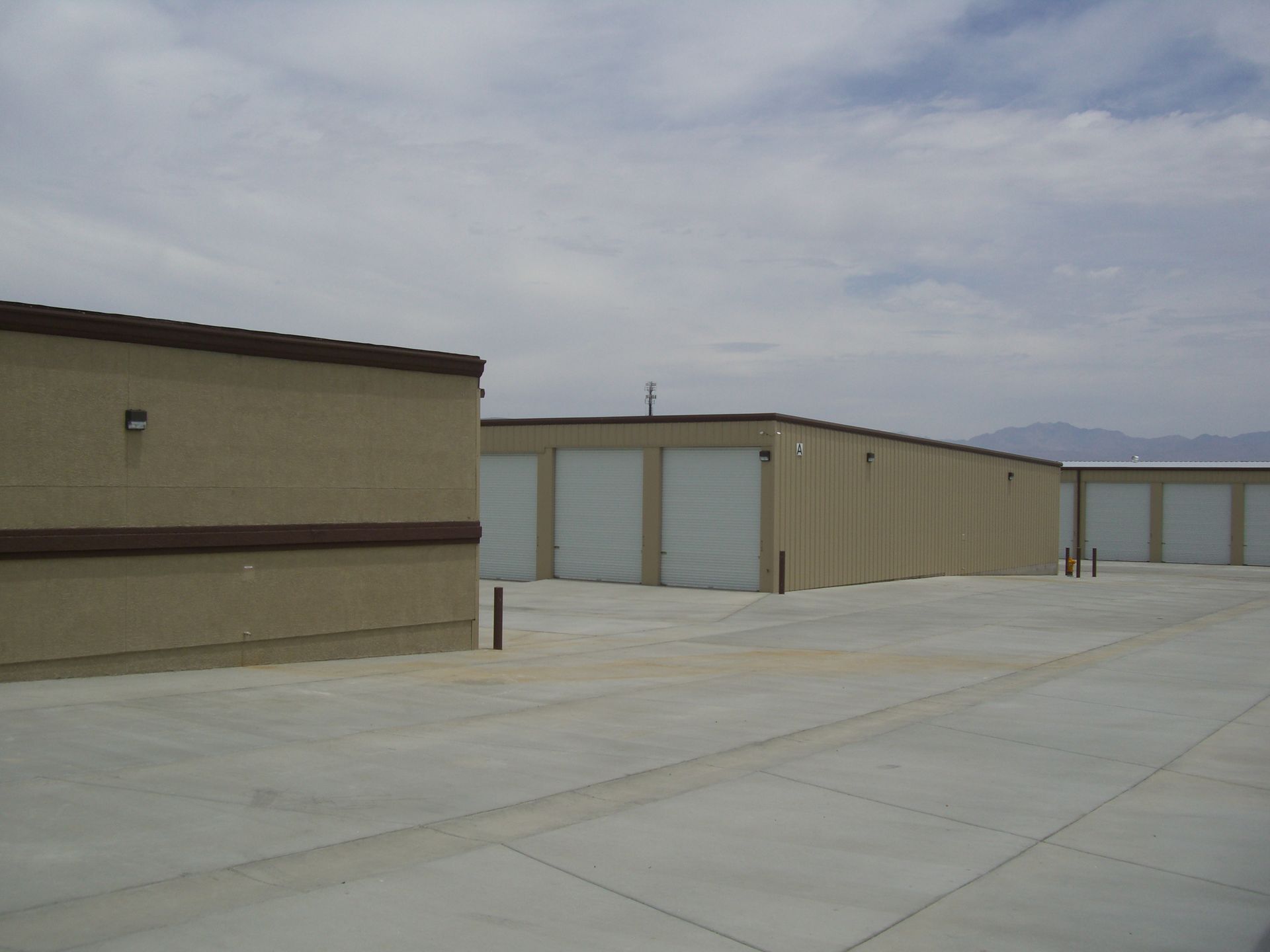 A row of storage units are lined up in a parking lot