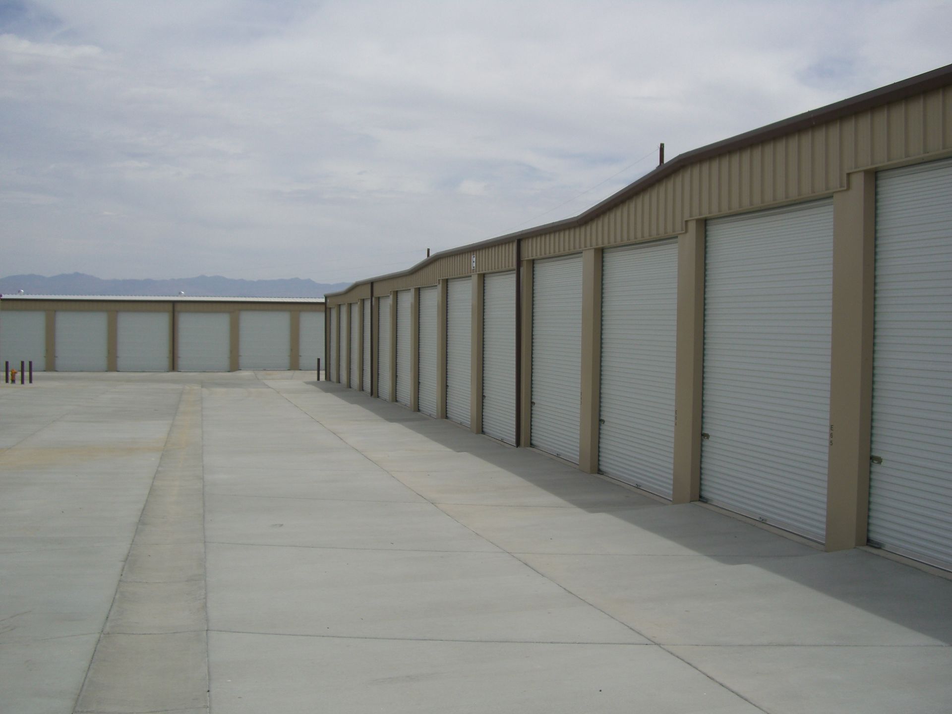 A row of garage doors are lined up in a parking lot