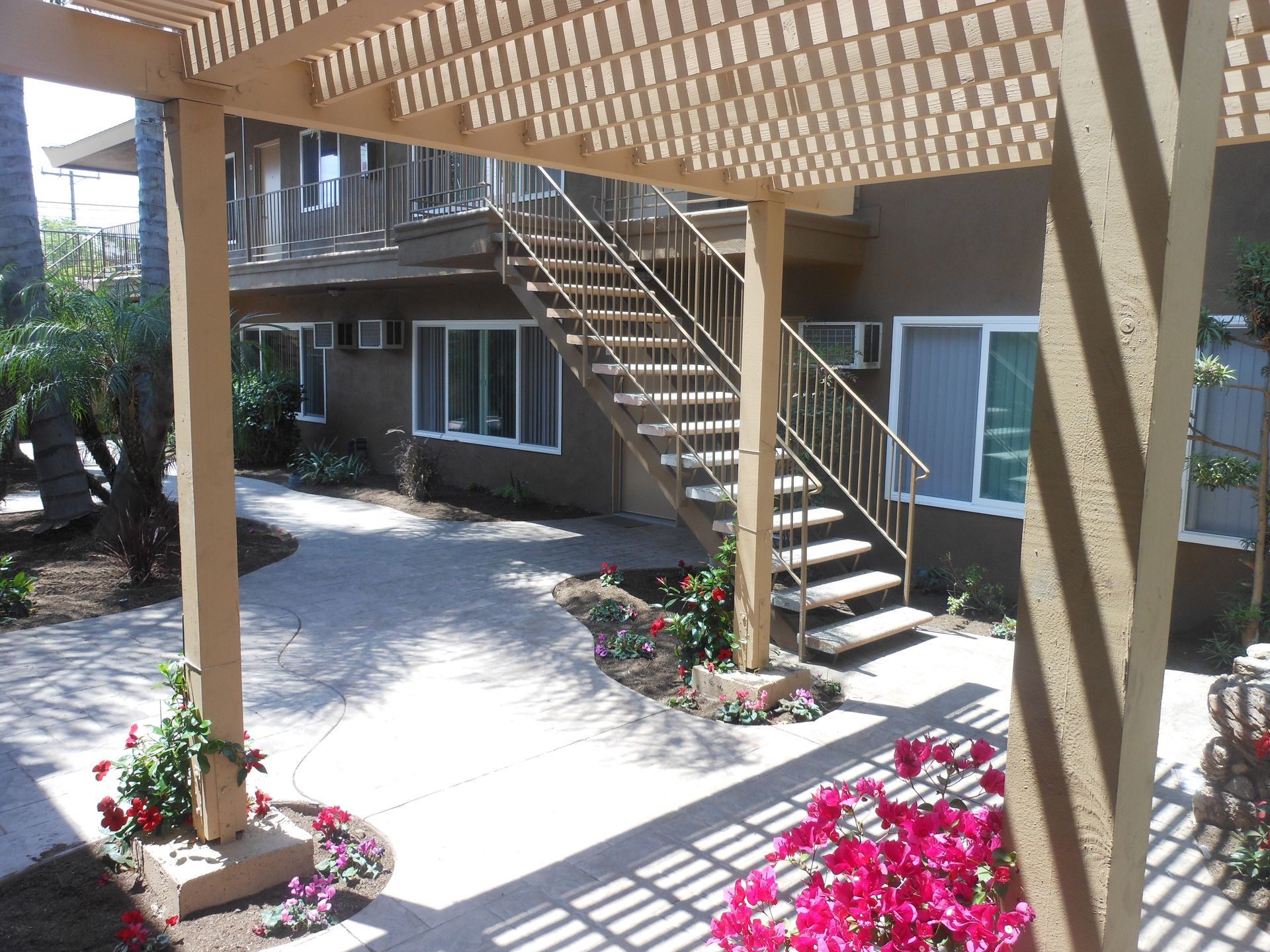 A building with stairs and a pergola in front of it