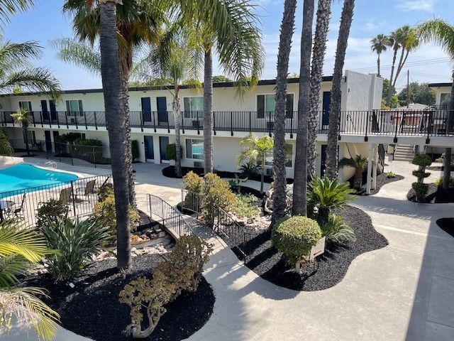 An aerial view of a hotel with palm trees and a pool