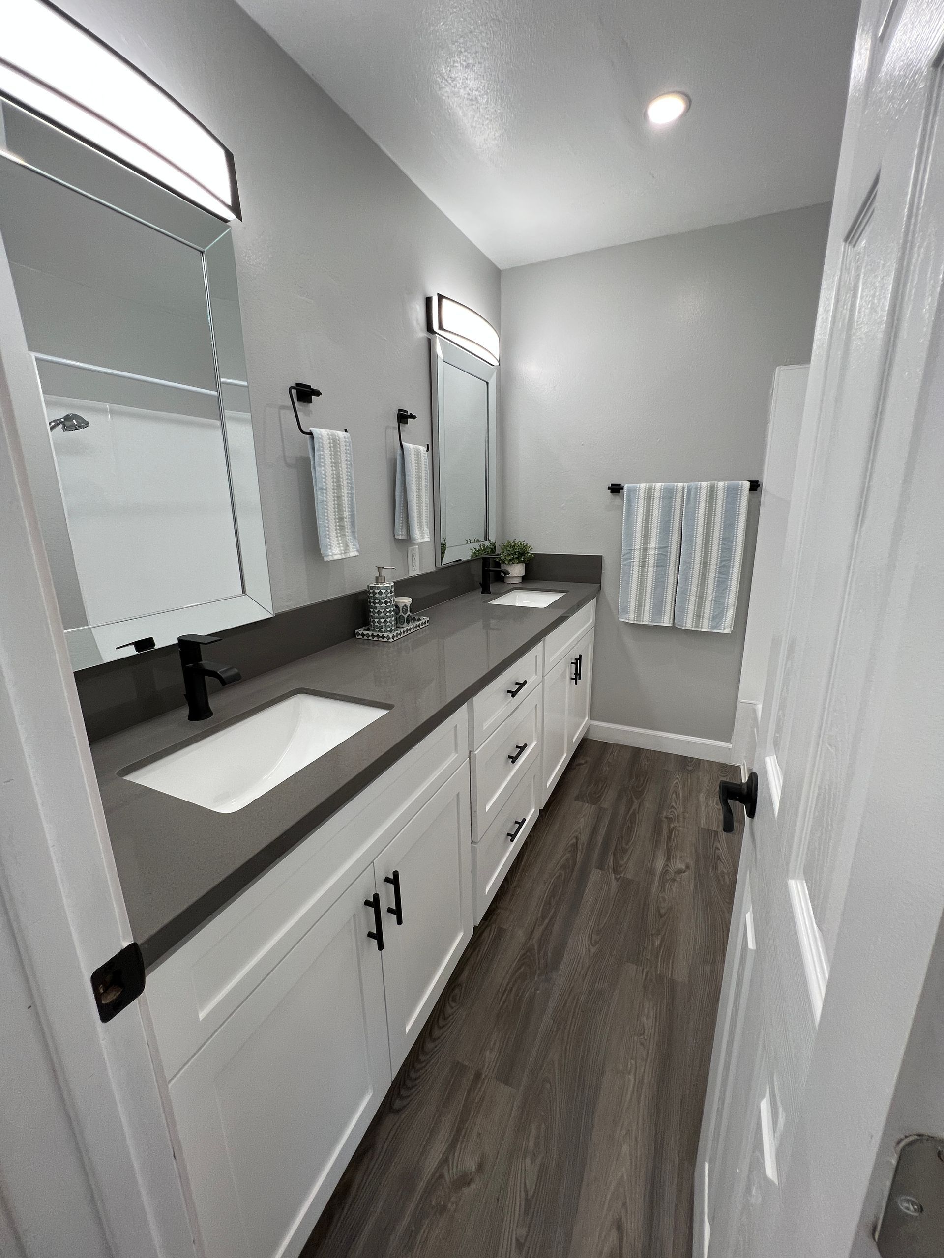A bathroom with two sinks and two mirrors.