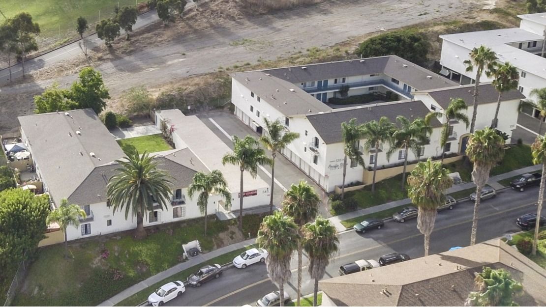 An aerial view of a residential area with palm trees and buildings
