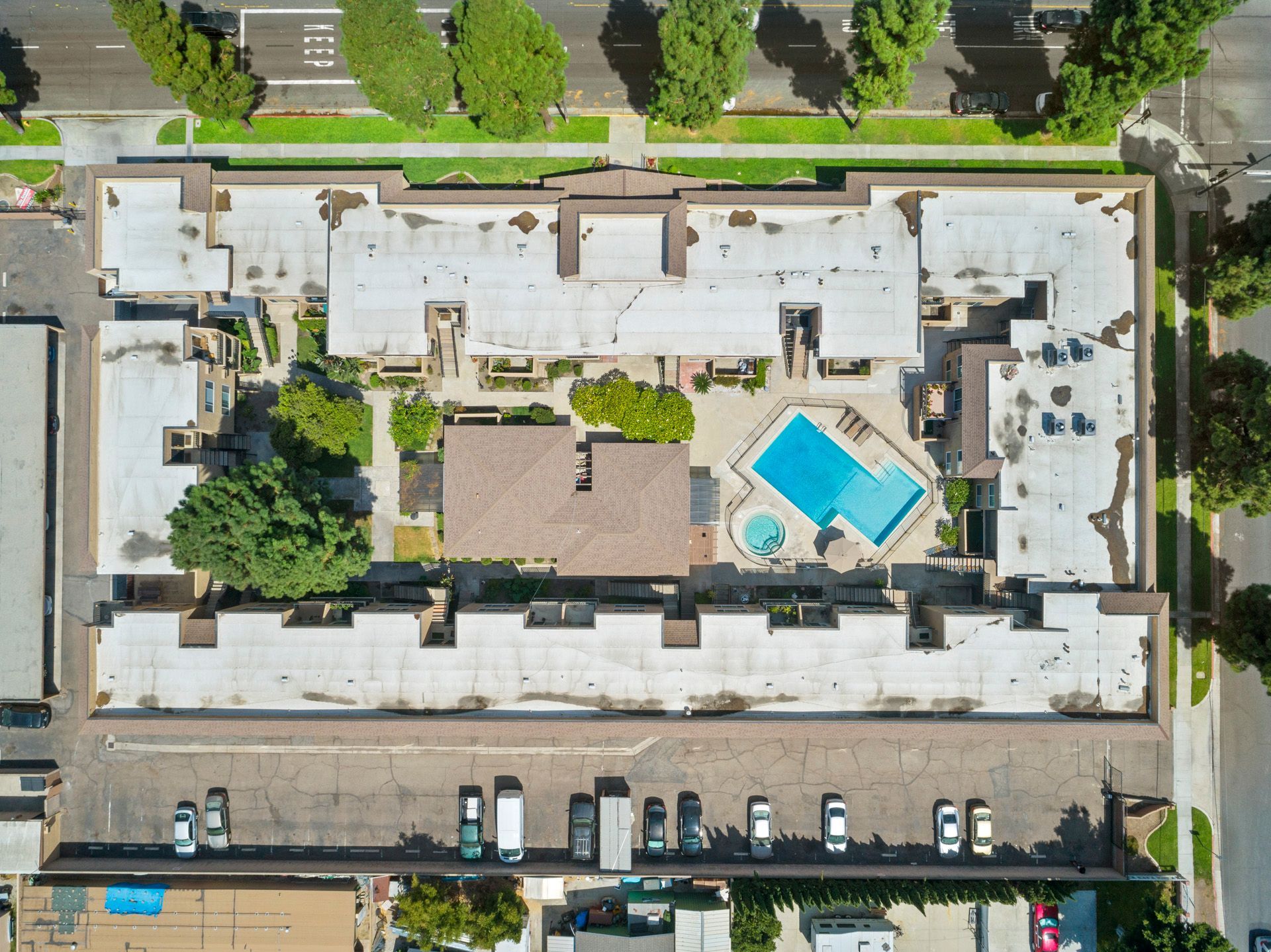An aerial view of a building with a pool in the middle