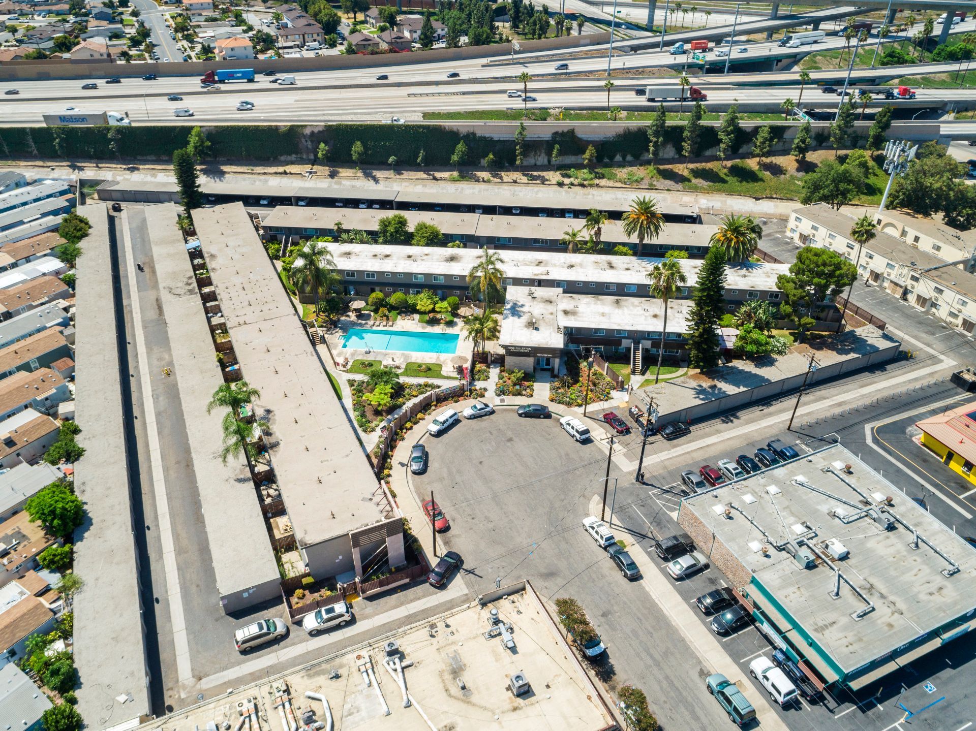 An aerial view of a hotel with a pool and parking lot