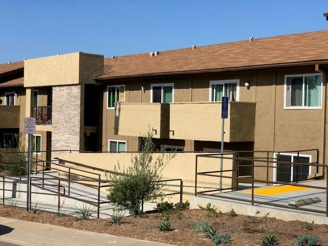 A large apartment building with a handicap ramp in front of it
